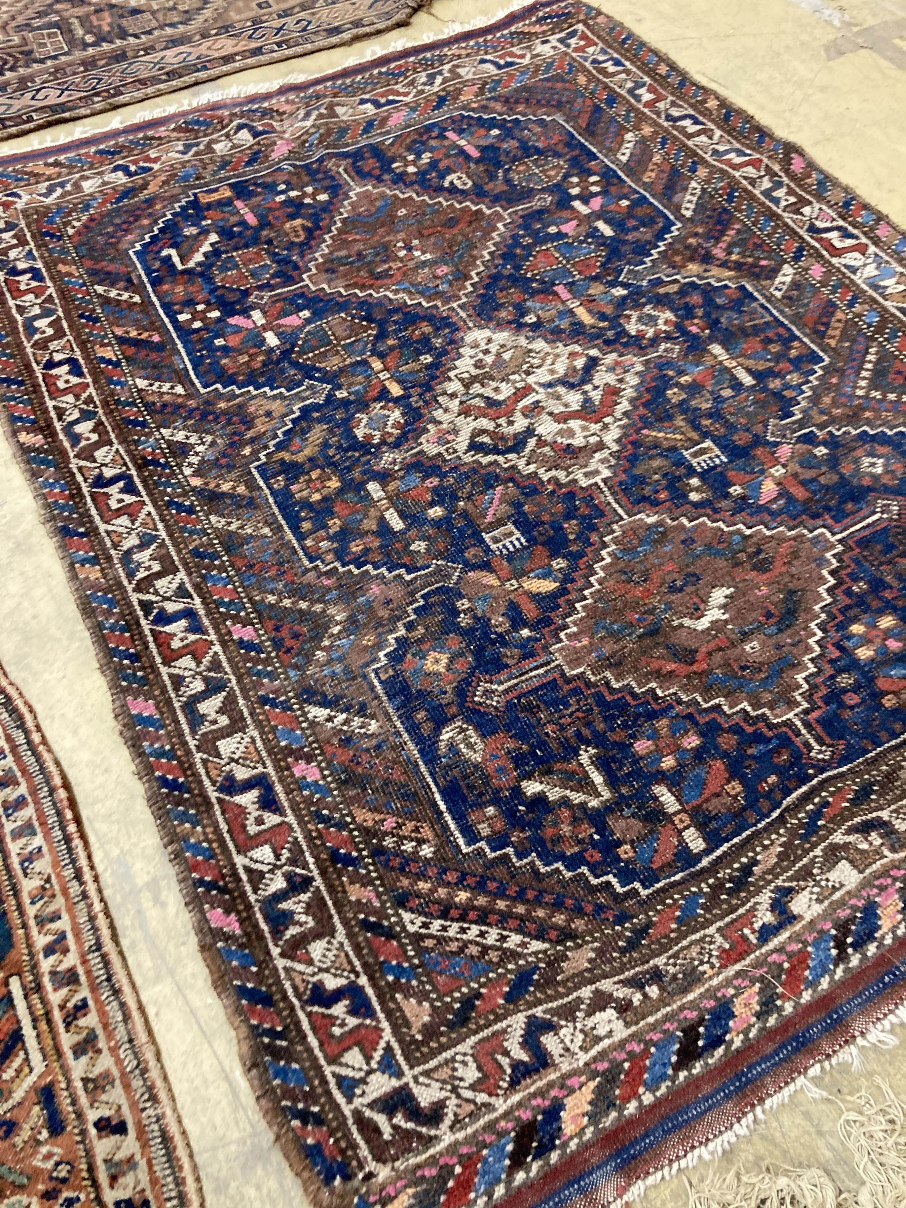Three antique Caucasian blue ground rugs, largest 154 x 114 cms.